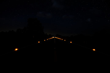 Fototapeta na wymiar Small light on the road in the night with star on the sky.
