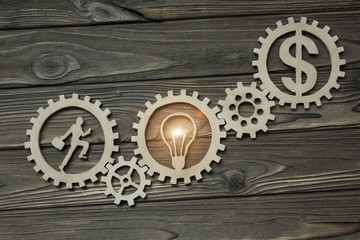businessman figure turns gears with symbols of the lamp and the dollar. business concept idea. Teamwork, innovation, industry. Cooperation