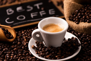 Cup of coffee surrounded by coffee beans
