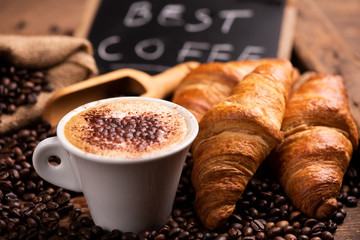 Cup of coffee surrounded by coffee beans