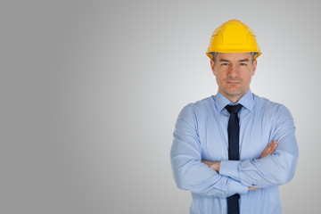 Architect with hands folded on gray background.