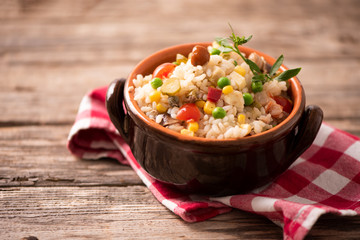 Rice salad in a bowl on wooded table