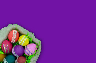 Basket with Easter eggs on a violet background