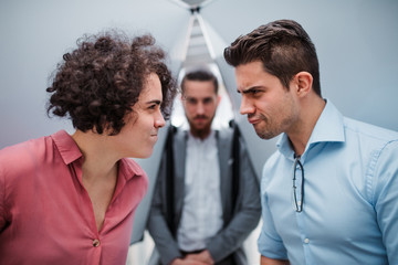 A group of young businesspeople standing in office, having fun.