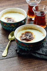 Turkish rice pudding, black tea, wooden table, close-up