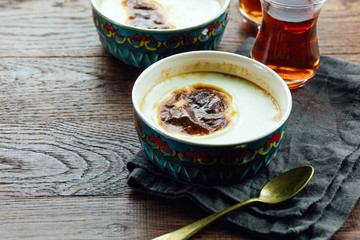 Turkish rice pudding, black tea, wooden table, close-up