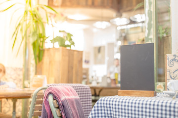 Blank chalkboard standing on table over blur cafe with bokeh background
