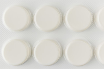 White pills in light packaging close-up. Minimalistic image suitable as a background on the theme of medicine and health.