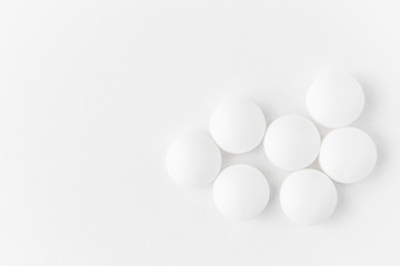 White pills on a light background close-up. Minimalistic image suitable as a background on the theme of medicine and health.