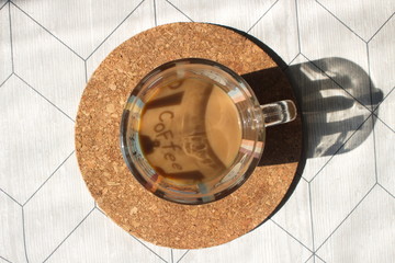 A cup of coffee with milk on a cork base
