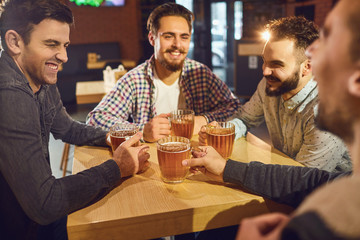 Friends talk, drink beer in a bar.