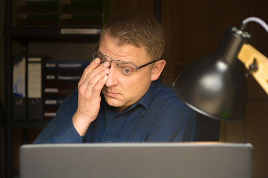 Gereizte Augen eines Mannes nach stundenlanger Arbeit am Computerbildschirm