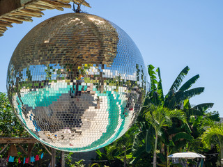 Disco ball reflecting green swimming pool. Bali.