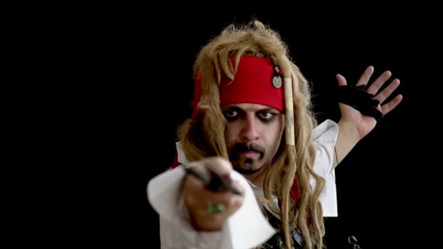 Children's animator dressed as a pirate with dreadlocks and a mustache, brandishing a sword, grimaces and swinging from side to