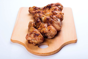 Grilled chicken drumstick on a wooden plate