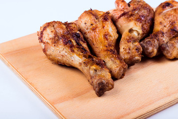 Grilled chicken drumstick on a wooden plate