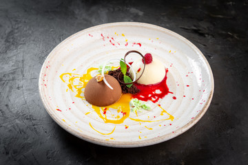 Italian Colorful ice cream scoops semifreddo with chocolate and raspberry on white plate on stone background