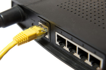 wireless router with yellow internet cable on white background