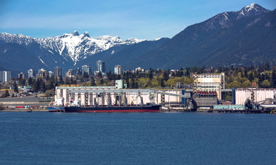 Terminal of North Vancouver port on a background of mountain scenery. The vessel is under load, the...