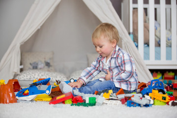 Child toddler playing with construction toys at home