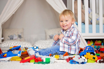 Child toddler playing with construction toys at home