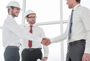 Two architects shaking hands after a meeting in office