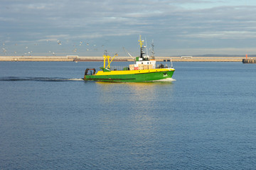 a small fishing boat returns to port