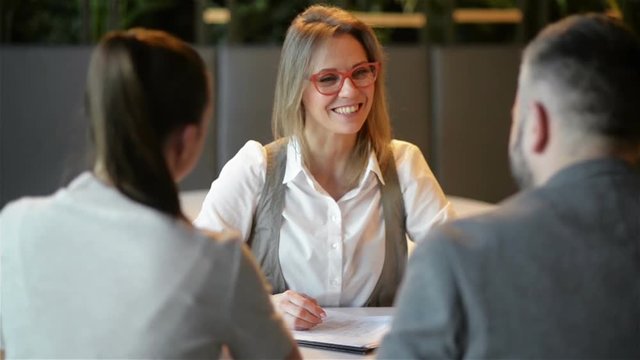 Meeting With Agent in Office. Young Family Is Buying Renting Apartment Or House. Family Couple Getting Key from Realtor After Signing Documents For Realty Purchase.