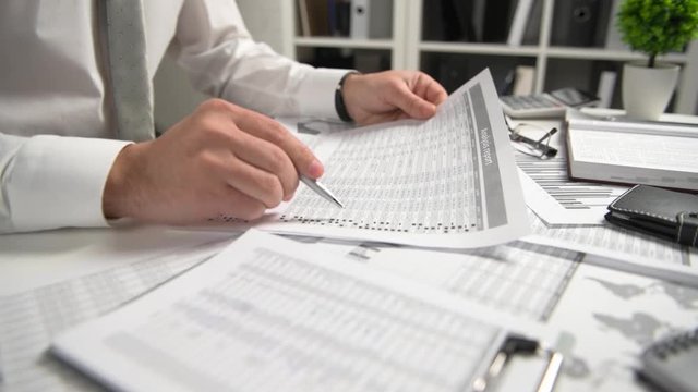 Businessman working at office and calculating finance, reads and writes reports. Business financial accounting concept.