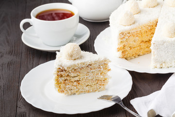 Homemade honey cake with sour cream on a wooden table with raisins and nuts
