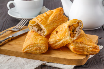 Puff pastry triangles filled with feta cheese and spinach on wooden table