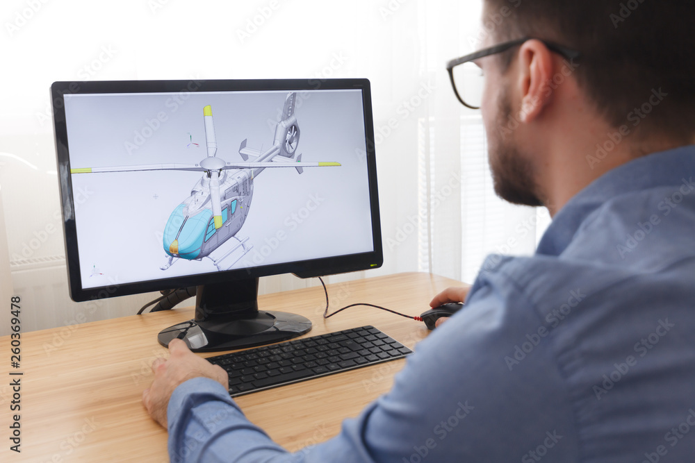 Wall mural engineer, constructor, designer in glasses working on a personal computer. he is creating, designing