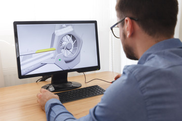 Engineer, Constructor, Designer in Glasses Working on a Personal Computer. He is Creating,...