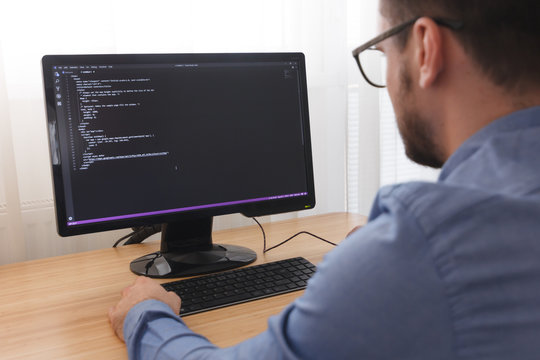 Programmer in Glsses Typing New Lines of HTML Code. Web Design Business and Web Development Concept. Freelance Work