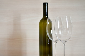 Bottle of wine and wine glass stemware in the simple interior of the apartment
