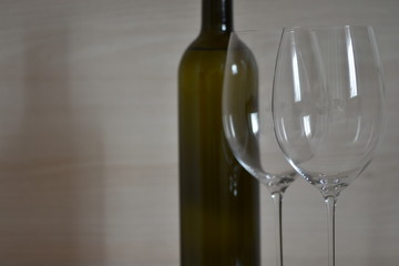 Bottle of wine and wine glass stemware in the simple interior of the apartment