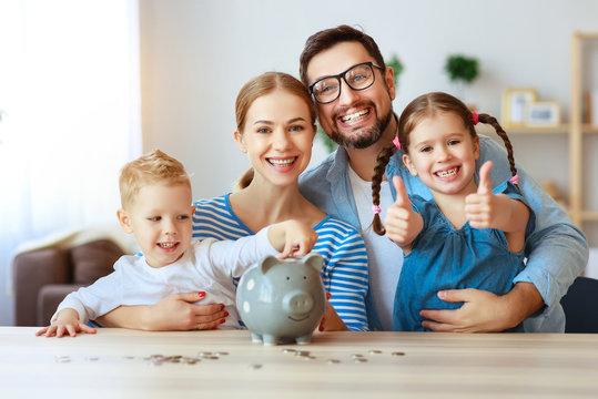 financial planning   family mother father and children with piggy Bank at home.