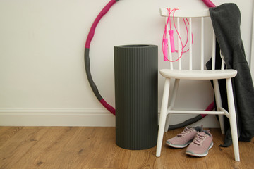 Fitness, yoga, sport concept - yoga mat, skipping rope, sport shoes and hula hoop - a large hoop...