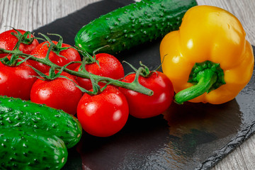 Tomatoes are among the vegetables on the slate Board.