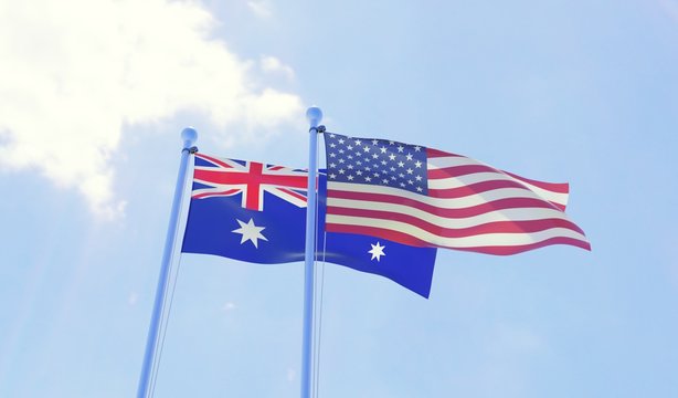 Australia and USA, two flags waving against blue sky. 3d image