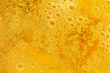 Close up of beer bubbles and foam as a background. Droplets on freshly poured beer texture.