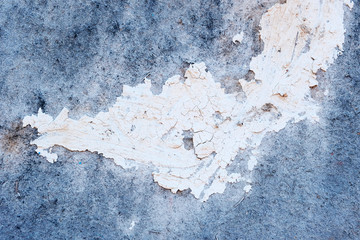 Pale blue stone texture of the wall. White paint stain on the surface. Copyspace.