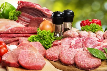 Raw Meat slices and knife on cutting board