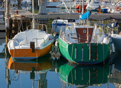 Two Colorful Sailboats Moored in a Marina