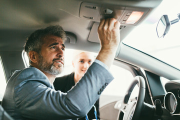 man buying a new car in car showroom