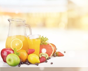 Tasty fruits  and juice with vitamins on background