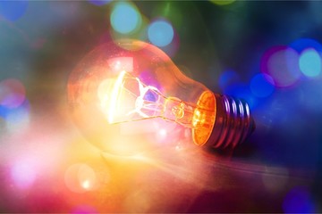 Glowing glass light bulb on background