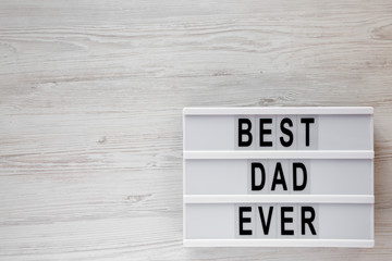 'Best dad ever' words on lightbox over white wooden surface, top view. Overhead, from above, flat...