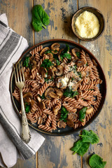Whole wheat fusilli pasta with mushroom and spinach.Top view with copy space.