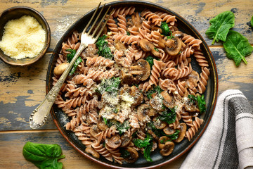 Whole wheat fusilli pasta with mushroom and spinach.Top view with copy space.